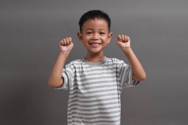 Beyaz arka planda poz veren Asyalı bir çocuk resmi. Asyalı bir çocuğun portresi