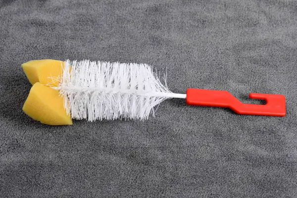 Koyu renk bir arka planda süngerli şişe fırçası. Bardaklar ve şişeler için fırça temizleyicisi