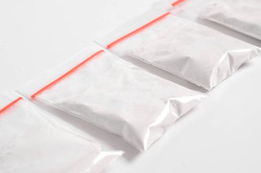 Beyaz arka planda izole edilmiş plastik pakette kokain. Yasadışı uyuşturucu maddeler, beyaz toz, narkotik