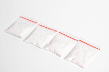 Beyaz arka planda izole edilmiş plastik pakette kokain. Yasadışı uyuşturucu maddeler, beyaz toz, narkotik