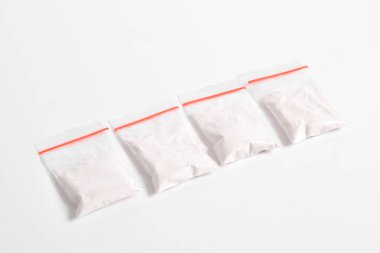 Beyaz arka planda izole edilmiş plastik pakette kokain. Yasadışı uyuşturucu maddeler, beyaz toz, narkotik