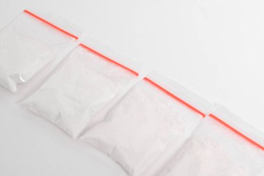 Beyaz arka planda izole edilmiş plastik pakette kokain. Yasadışı uyuşturucu maddeler, beyaz toz, narkotik