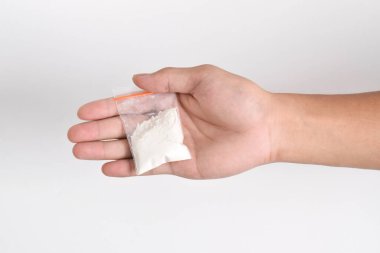 Beyaz arka planda izole edilmiş plastik pakette el yapımı kokain. Yasadışı uyuşturucu maddelerinin ve uyuşturucuların gösterimi