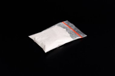 Siyah arka planda izole edilmiş plastik pakette kokain. Yasadışı uyuşturucu maddelerinin ve uyuşturucuların gösterimi
