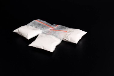 Siyah arka planda izole edilmiş plastik pakette kokain. Yasadışı uyuşturucu maddelerinin ve uyuşturucuların gösterimi