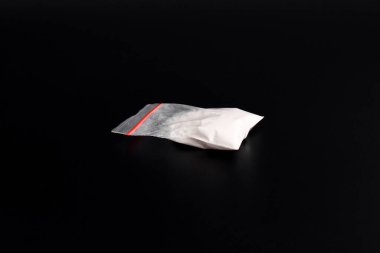 Siyah arka planda izole edilmiş plastik pakette kokain. Yasadışı uyuşturucu maddelerinin ve uyuşturucuların gösterimi