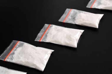 Siyah arka planda izole edilmiş plastik pakette kokain. Yasadışı uyuşturucu maddelerinin ve uyuşturucuların gösterimi
