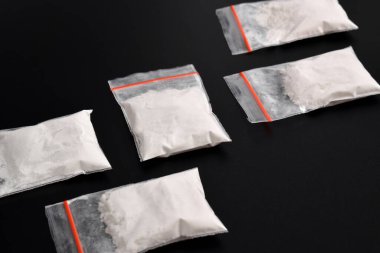 Siyah arka planda izole edilmiş plastik pakette kokain. Yasadışı uyuşturucu maddelerinin ve uyuşturucuların gösterimi