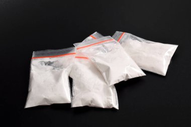 Siyah arka planda izole edilmiş plastik pakette kokain. Yasadışı uyuşturucu maddelerinin ve uyuşturucuların gösterimi