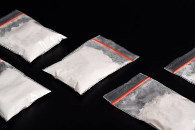 Siyah arka planda izole edilmiş plastik pakette kokain. Yasadışı uyuşturucu maddelerinin ve uyuşturucuların gösterimi
