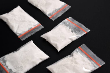 Siyah arka planda izole edilmiş plastik pakette kokain. Yasadışı uyuşturucu maddelerinin ve uyuşturucuların gösterimi