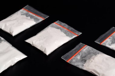Siyah arka planda izole edilmiş plastik pakette kokain. Yasadışı uyuşturucu maddelerinin ve uyuşturucuların gösterimi