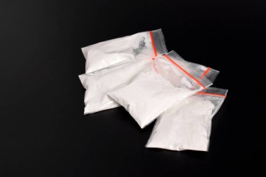 Siyah arka planda izole edilmiş plastik pakette kokain. Yasadışı uyuşturucu maddelerinin ve uyuşturucuların gösterimi