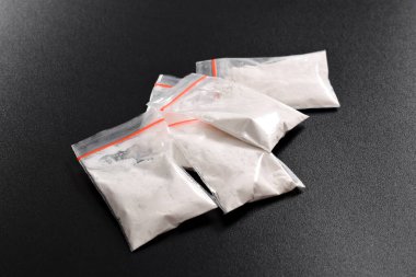 Siyah arka planda izole edilmiş plastik pakette kokain. Yasadışı uyuşturucu maddelerinin ve uyuşturucuların gösterimi