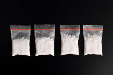 Siyah arka planda izole edilmiş plastik pakette kokain. Yasadışı uyuşturucu maddelerinin ve uyuşturucuların gösterimi