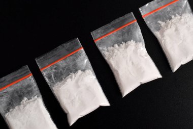 Siyah arka planda izole edilmiş plastik pakette kokain. Yasadışı uyuşturucu maddelerinin ve uyuşturucuların gösterimi