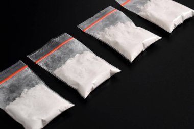 Siyah arka planda izole edilmiş plastik pakette kokain. Yasadışı uyuşturucu maddelerinin ve uyuşturucuların gösterimi