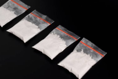 Siyah arka planda izole edilmiş plastik pakette kokain. Yasadışı uyuşturucu maddelerinin ve uyuşturucuların gösterimi