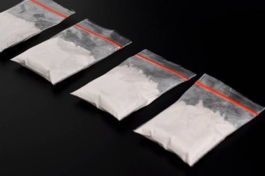 Siyah arka planda izole edilmiş plastik pakette kokain. Yasadışı uyuşturucu maddelerinin ve uyuşturucuların gösterimi