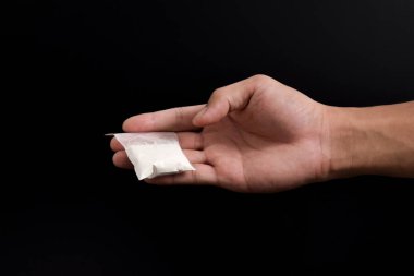 Siyah arka planda izole edilmiş plastik pakette el yapımı kokain. Yasadışı uyuşturucu maddelerinin ve uyuşturucuların gösterimi