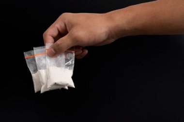 Siyah arka planda izole edilmiş plastik pakette el yapımı kokain. Yasadışı uyuşturucu maddelerinin ve uyuşturucuların gösterimi