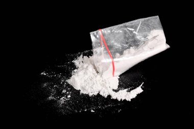 Siyah arkaplana serpiştirilmiş plastik pakette kokain. Yasadışı uyuşturucu maddelerinin ve uyuşturucuların gösterimi