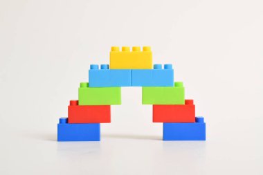 Beyaz arka planda izole bir gökkuşağı renkli lego merdiveni. İnşa Blokları