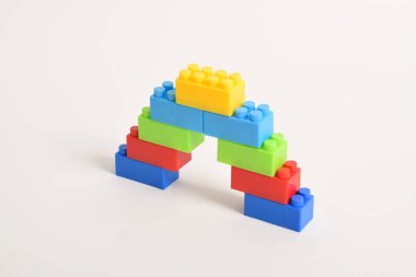 Beyaz arka planda izole bir gökkuşağı renkli lego merdiveni. İnşa Blokları