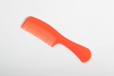 Kırmızı renkli plastik saç tarağı beyaz arkaplanda izole edildi