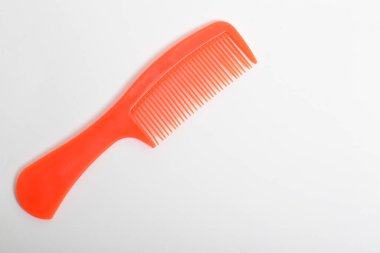 Kırmızı renkli plastik saç tarağı beyaz arkaplanda izole edildi