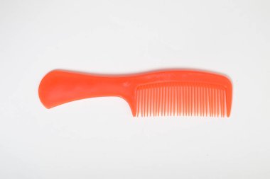 Kırmızı renkli plastik saç tarağı beyaz arkaplanda izole edildi