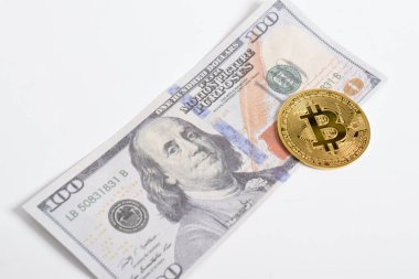 100 dolarlık banknotlarda Bitcoin 'in altın sembolik parası. İzole edilmiş arka plan. Bitcoin 'i bir dolarla takas et. Amerikan dolarları üzerinde kripto para birimi. Tasarruf, yatırım kavramı