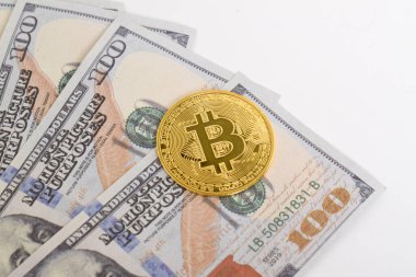 100 dolarlık banknotlarda Bitcoin 'in altın sembolik parası. İzole edilmiş arka plan. Bitcoin 'i bir dolarla takas et. Amerikan dolarları üzerinde kripto para birimi. Tasarruf, yatırım kavramı