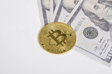 100 dolarlık banknotlarda Bitcoin 'in altın sembolik parası. İzole edilmiş arka plan. Bitcoin 'i bir dolarla takas et. Amerikan dolarları üzerinde kripto para birimi. Tasarruf, yatırım kavramı