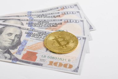 100 dolarlık banknotlarda Bitcoin 'in altın sembolik parası. İzole edilmiş arka plan. Bitcoin 'i bir dolarla takas et. Amerikan dolarları üzerinde kripto para birimi. Tasarruf, yatırım kavramı