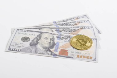 100 dolarlık banknotlarda Bitcoin 'in altın sembolik parası. İzole edilmiş arka plan. Bitcoin 'i bir dolarla takas et. Amerikan dolarları üzerinde kripto para birimi. Tasarruf, yatırım kavramı