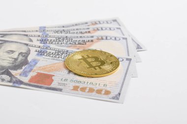 100 dolarlık banknotlarda Bitcoin 'in altın sembolik parası. İzole edilmiş arka plan. Bitcoin 'i bir dolarla takas et. Amerikan dolarları üzerinde kripto para birimi. Tasarruf, yatırım kavramı