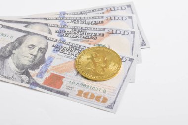 100 dolarlık banknotlarda Bitcoin 'in altın sembolik parası. İzole edilmiş arka plan. Bitcoin 'i bir dolarla takas et. Amerikan dolarları üzerinde kripto para birimi. Tasarruf, yatırım kavramı