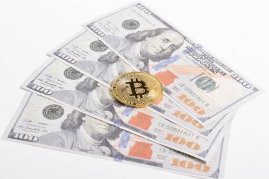 100 dolarlık banknotlarda Bitcoin 'in altın sembolik parası. İzole edilmiş arka plan. Bitcoin 'i bir dolarla takas et. Amerikan dolarları üzerinde kripto para birimi. Tasarruf, yatırım kavramı