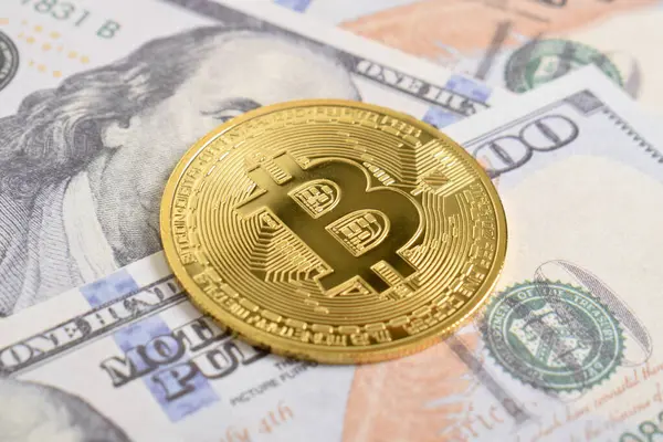 100 dolarlık banknotlarda Bitcoin 'in altın sembolik parası. Bitcoin 'i bir dolarla takas et. Amerikan dolarları üzerinde kripto para birimi. Tasarruf, yatırım konsepti. Dijital modern ödeme yöntemi