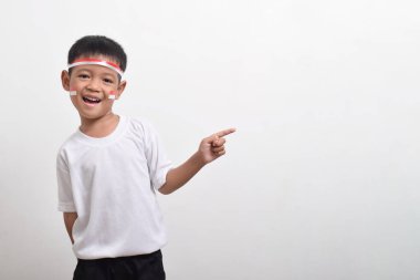 Yanındaki fotokopi odasını gösteren bantlı şirin Asyalı çocuk beyaz arka planda izole edilmiş. Endonezya 'nın bağımsızlık günü kavramı 17 Ağustos