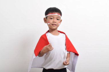 Endonezya bayraklı ve cüppeli şirin bir Asyalı çocuk. Endonezya 'nın bağımsızlık günü kavramı 17 Ağustos