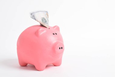 Pembe domuz kumbarası ve beyaz arka planda izole edilmiş Amerikan doları banknotları. Nakit para. Finans ve Yatırım kavramı