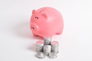 Pembe kumbara ve beyaz arka planda izole edilmiş bir yığın bozuk para. Yatırım bütçesi tasarruf emekliliği, finans, para, bankacılık konsepti. Boşluğu kopyala