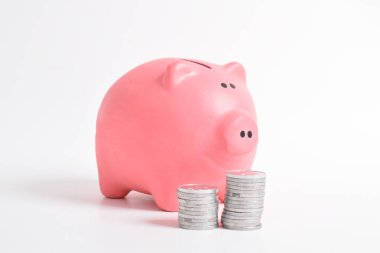 Pembe kumbara ve beyaz arka planda izole edilmiş bir yığın bozuk para. Yatırım bütçesi tasarruf emekliliği, finans, para, bankacılık konsepti. Boşluğu kopyala