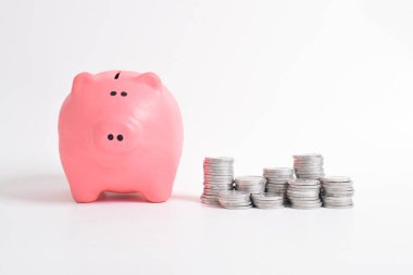 Pembe kumbara ve beyaz arka planda izole edilmiş bir yığın bozuk para. Yatırım bütçesi tasarruf emekliliği, finans, para, bankacılık konsepti. Boşluğu kopyala