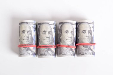 Beyaz arka planda izole edilmiş yüz dolarlık banknotlar. 100 dolarlık deste deste. Lastik bantla sarılmış..