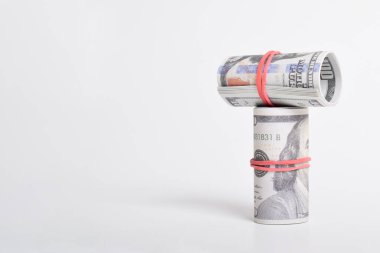 Kırmızı lastikle sarılmış dolar rulosu. Beyaz arka planda izole edilmiş 100 dolarlık banknotlar. Yuvarlanan Amerikan doları banknotları