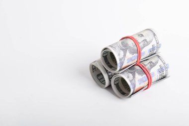 Beyaz arka planda izole edilmiş bir tomar para. Yüz dolar nakit, kırmızı kauçukla sarılmış. Amerikan doları. 100 dolarlık banknotlar