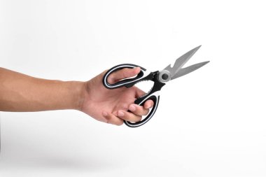 El ele tutuşan mutfak makası beyaz arka planda paslanmaz çelik makası..